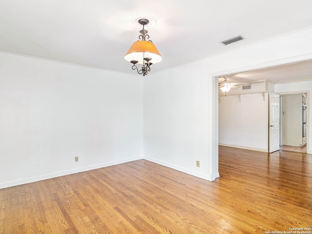 unfurnished room with light wood-style floors, baseboards, ceiling fan, and visible vents