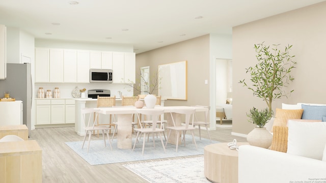 kitchen featuring range, light countertops, white cabinets, freestanding refrigerator, and light wood finished floors