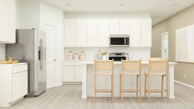 kitchen with a center island, light wood finished floors, white cabinets, and stainless steel appliances