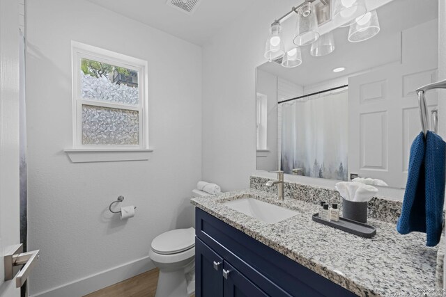 1880 Trail Pass Dr, Canyon Lake, TX 78133 - full bathroom featuring visible vents, vanity, wood finished floors, toilet, and baseboards