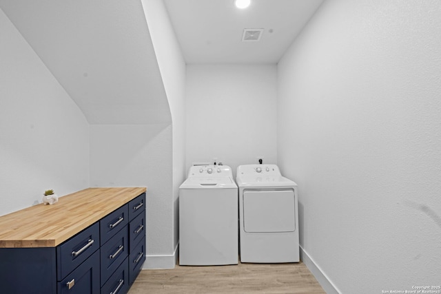1880 Trail Pass Dr, Canyon Lake, TX 78133 - laundry room featuring washing machine and clothes dryer, cabinet space, light wood-style floors, baseboards, and visible vents