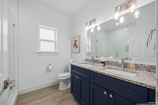 1880 Trail Pass Dr, Canyon Lake, TX 78133 - bathroom featuring wood finished floors, toilet, a sink, and a stall shower