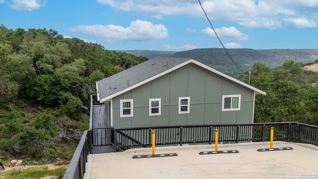 1880 Trail Pass Dr, Canyon Lake, TX 78133 - rear view of property with a shingled roof, a mountain view, and a forest view