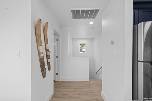 1880 Trail Pass Dr, Canyon Lake, TX 78133 - hall featuring visible vents, light wood-style flooring, baseboards, and an upstairs landing