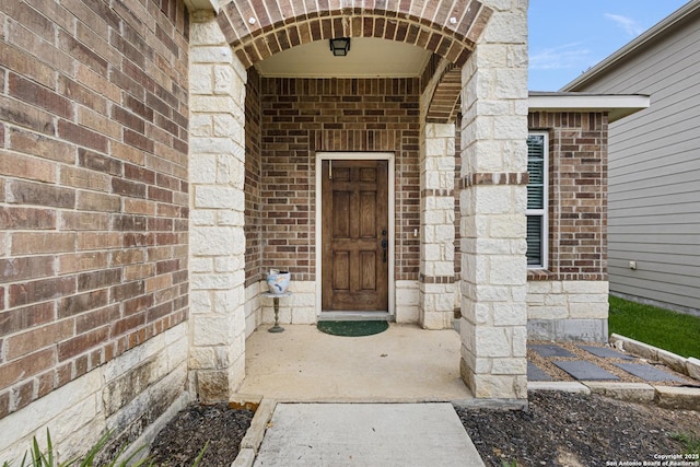 view of exterior entry with brick siding