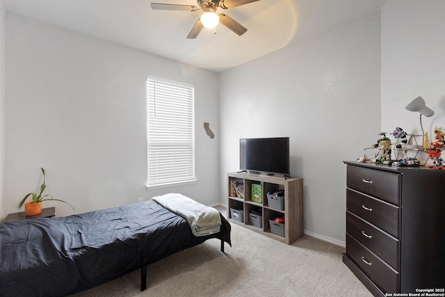 bedroom featuring baseboards, a ceiling fan, and light colored carpet