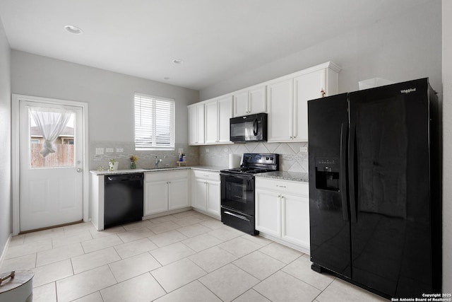 kitchen with white cabinets, decorative backsplash, a sink, and black appliances