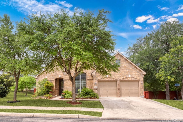 obstructed view of property featuring a garage, driveway, a front lawn, and brick siding