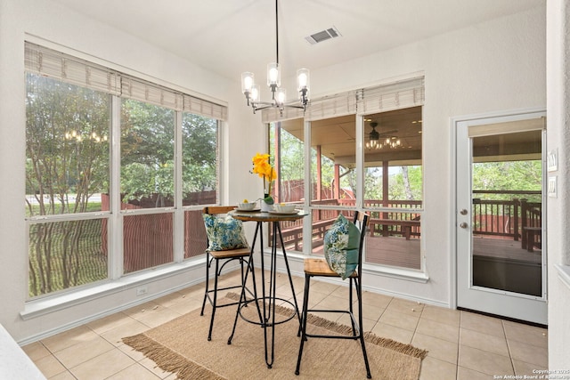 sunroom / solarium featuring visible vents and ceiling fan with notable chandelier