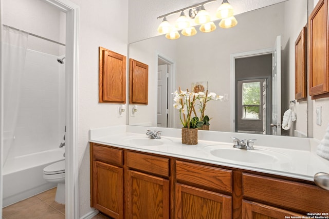 bathroom featuring double vanity, a sink, tile patterned floors, and toilet