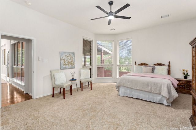 carpeted bedroom with baseboards, ceiling fan, and visible vents