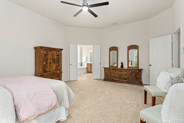 bedroom with visible vents, baseboards, ceiling fan, light colored carpet, and ensuite bath