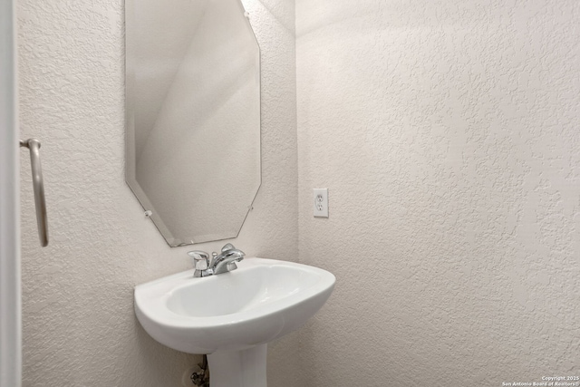 bathroom with a sink and a textured wall