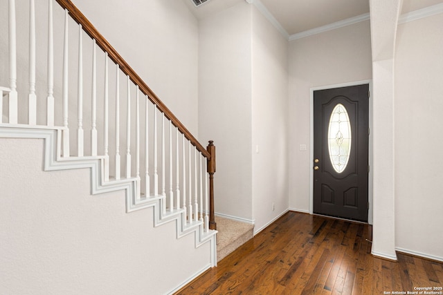 foyer with wood-type flooring, ornamental molding, stairs, and baseboards
