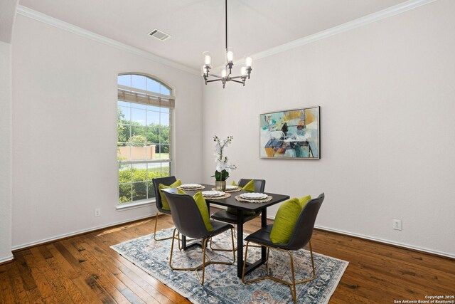 dining space with visible vents, crown molding, baseboards, wood-type flooring, and a notable chandelier