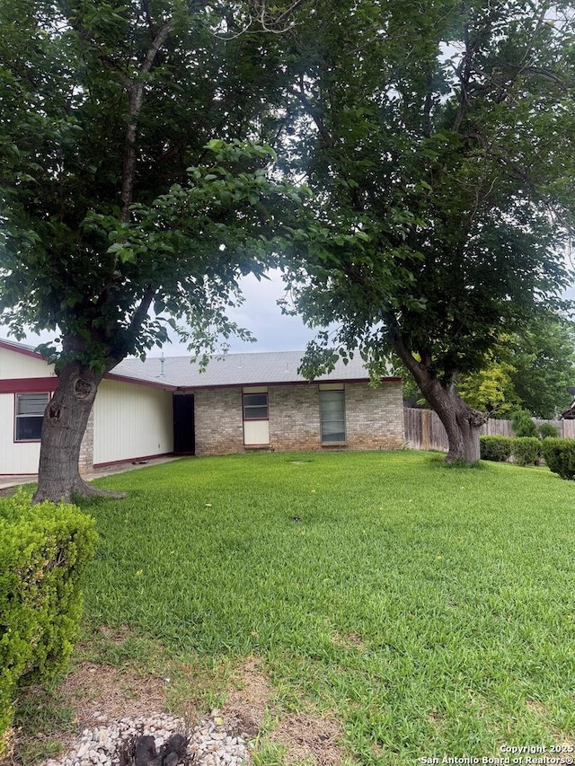 1074 Honeytree St, San Antonio, TX 78245 - view of front of property featuring fence, stone siding, and a front yard