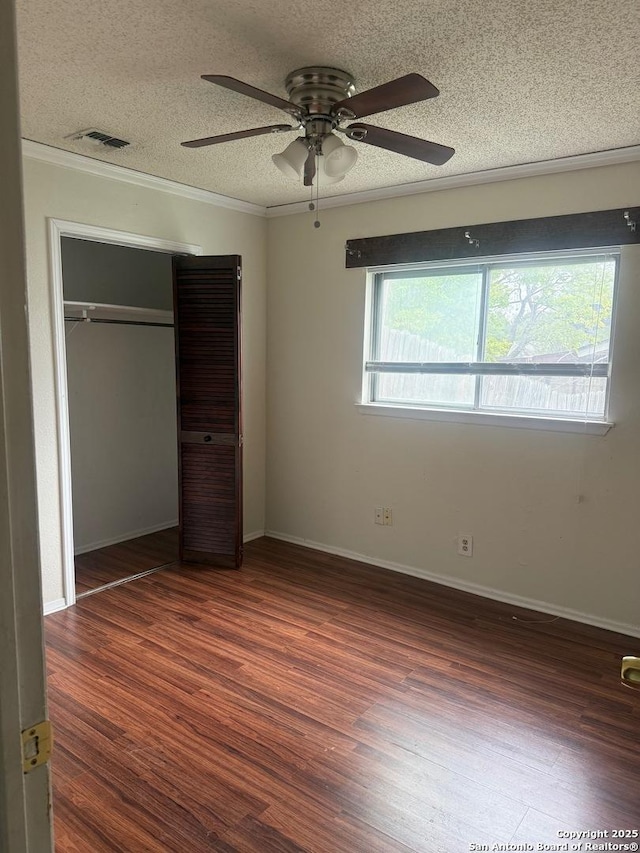 1074 Honeytree St, San Antonio, TX 78245 - unfurnished bedroom featuring crown molding, a textured ceiling, visible vents, and wood finished floors