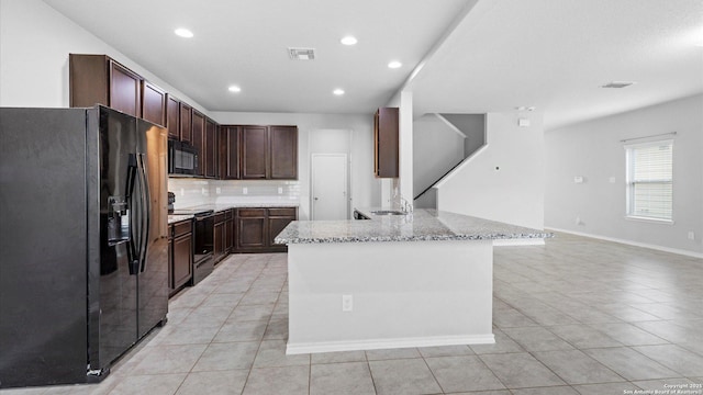7350 Braes Cor, San Antonio, TX 78244 - kitchen with black appliances, light tile patterned floors, backsplash, light stone counters, and recessed lighting
