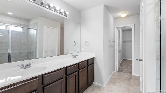 7350 Braes Cor, San Antonio, TX 78244 - bathroom with a stall shower, double vanity, a spacious closet, baseboards, and tile patterned flooring