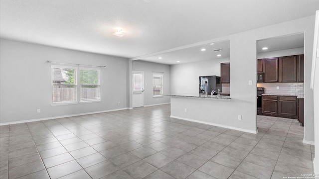 7350 Braes Cor, San Antonio, TX 78244 - unfurnished living room featuring healthy amount of natural light, light tile patterned flooring, recessed lighting, and baseboards