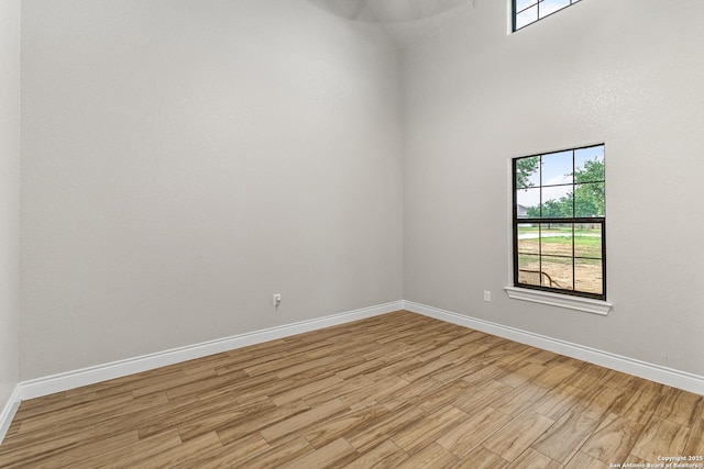 empty room featuring baseboards and light wood-type flooring