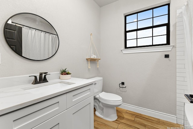 full bath featuring baseboards, wood finished floors, a wealth of natural light, and toilet