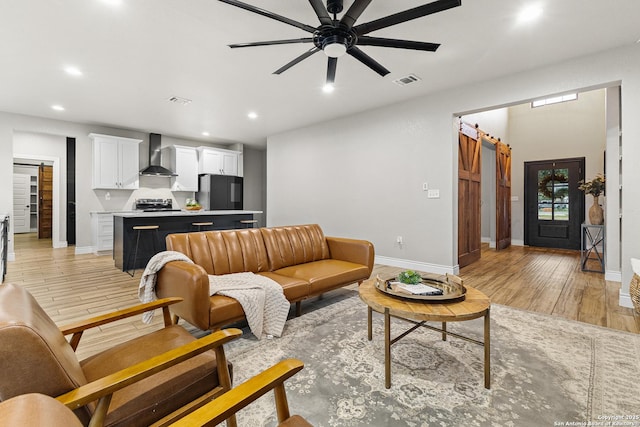 living area featuring light wood-style floors, recessed lighting, baseboards, and visible vents