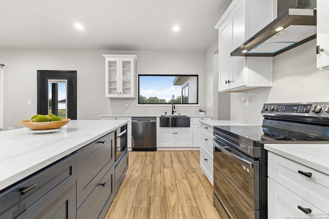 kitchen featuring white cabinets, electric range, a sink, dishwasher, and wall chimney exhaust hood