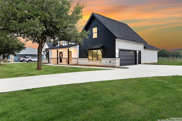 modern farmhouse featuring roof with shingles, a front lawn, concrete driveway, an attached garage, and stone siding