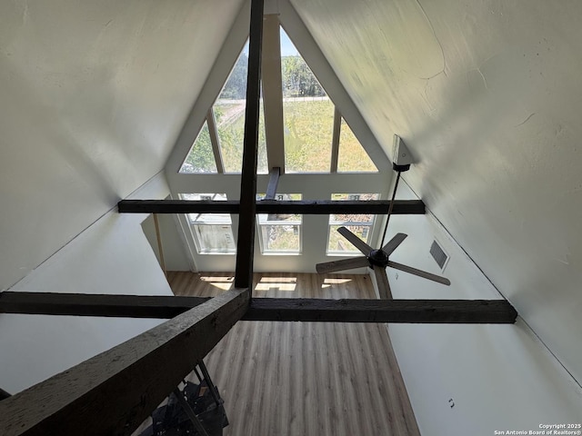 staircase with ceiling fan, wood finished floors, and lofted ceiling