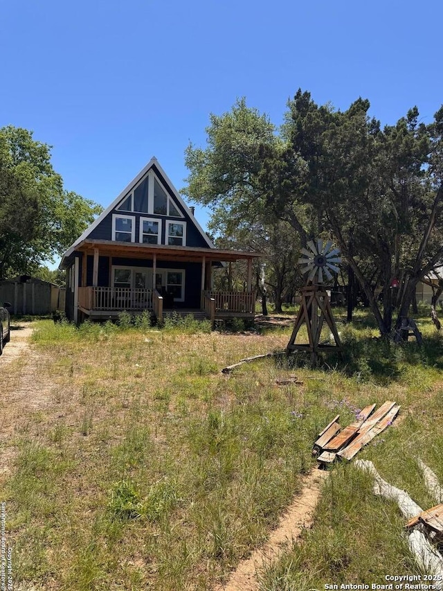 rear view of house featuring covered porch