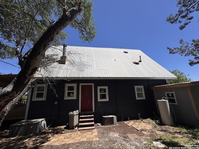 view of front of house featuring central AC unit, metal roof, and entry steps