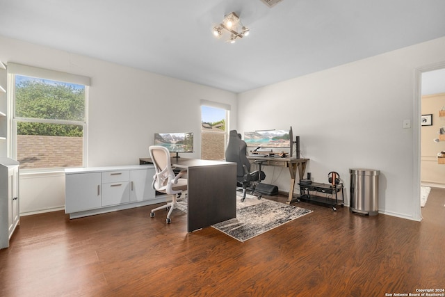 office space featuring baseboards, visible vents, a healthy amount of sunlight, and wood finished floors