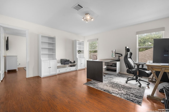 office area featuring visible vents, a healthy amount of sunlight, and dark wood finished floors