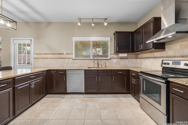 kitchen with decorative backsplash, dark brown cabinetry, wall chimney range hood, a sink, and appliances with stainless steel finishes
