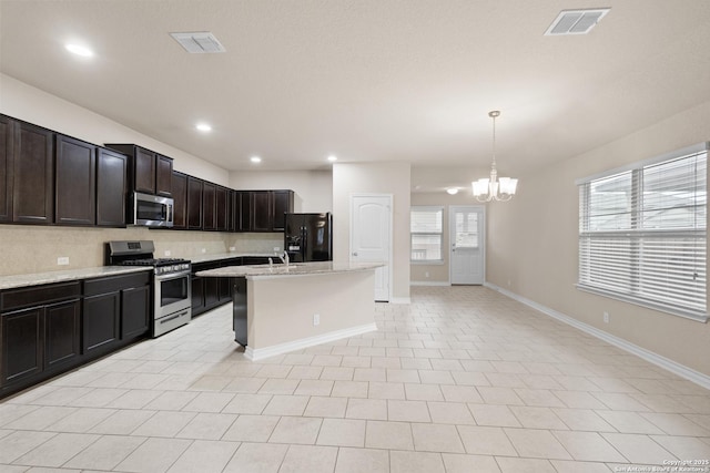 kitchen featuring an inviting chandelier, appliances with stainless steel finishes, baseboards, and visible vents
