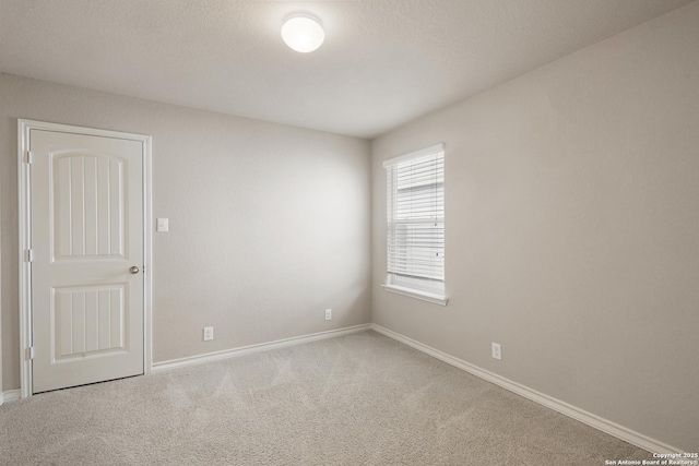 empty room with baseboards and carpet flooring