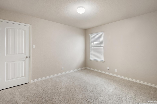 carpeted spare room featuring baseboards