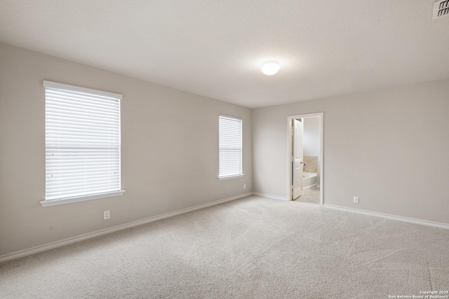 unfurnished room featuring baseboards, visible vents, and light colored carpet