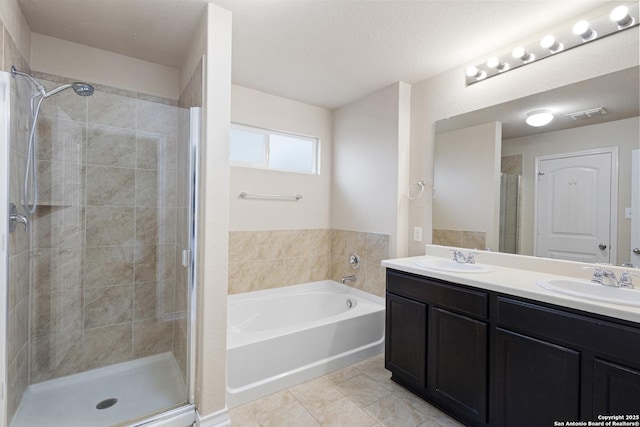 bathroom with a sink, a bath, and a stall shower
