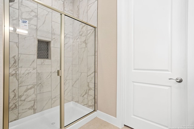 bathroom with baseboards and a shower stall