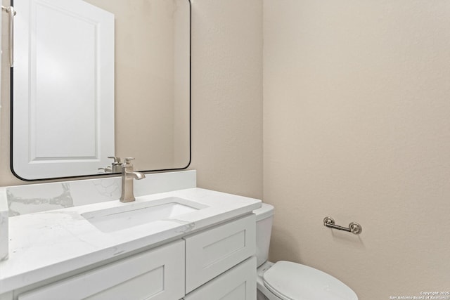 half bathroom with vanity and toilet