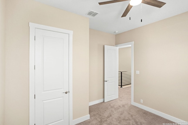 unfurnished bedroom with visible vents, baseboards, ceiling fan, and light carpet