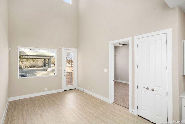 entrance foyer featuring plenty of natural light, light wood-style floors, and a high ceiling