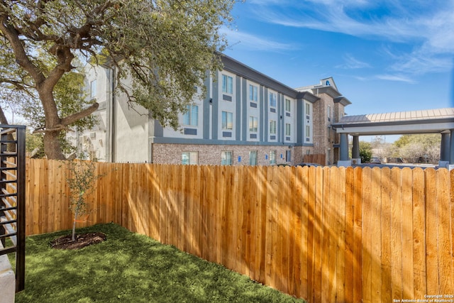 view of side of home featuring brick siding, fence, and stucco siding
