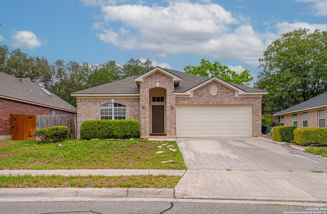 single story home with brick siding, fence, driveway, and a garage
