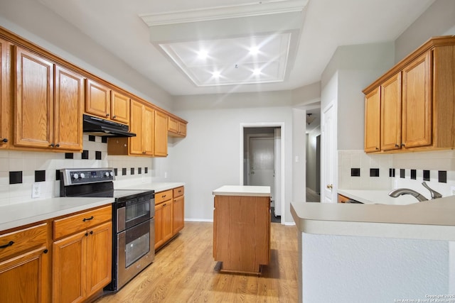 kitchen featuring under cabinet range hood, decorative backsplash, double oven range, and light countertops