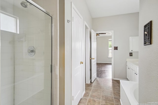 full bath with baseboards, a shower stall, a garden tub, and vanity