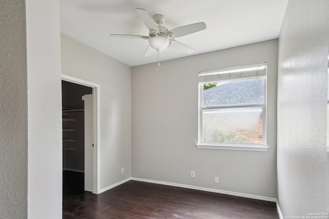 unfurnished room featuring dark wood-style flooring, baseboards, and ceiling fan