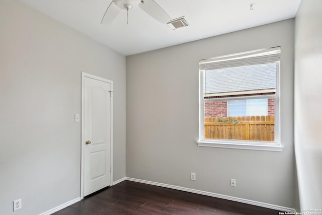 unfurnished room featuring visible vents, a ceiling fan, dark wood-style flooring, and baseboards